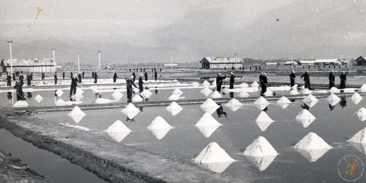 កសិករកំពុងកៀរប្រមូលអំបិលក្នុងស្រែអំបិលនៅខេត្តកំពត ក្នុងរបបខ្មែរក្រហម(រវាងឆ្នាំ១៩៧៥-១៩៧៩) បណ្ណសារមជ្ឈមណ្ឌលឯកសារកម្ពុជា។