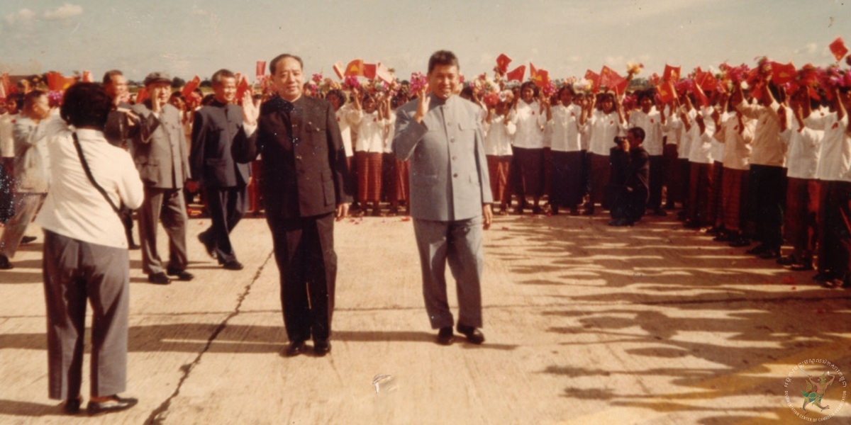(Center, right): Pol Pot, Prime Minister and Secretary of Communist Party of Kampuchea (CPK) with Wang Dong Xing, Deputy Head of Chinese Communist Party’s Central Committee. (Behind Wang Dong Xing): Khieu Samphan, President of State’s Presidium of Democratic Kampuchea. (First from left): Hu Yao Bang, General Secretary of Chinese Communist Party’s Central Committee. (Second from left): Nuon Chea, President of People’s Representative Assembly and Deputy Secretary of Communist Party of Kampuchea. On Friday 16 November, 2018, the Khmer Rouge Tribunal convicted Nuon Chea and Khieu Samphan of genocide, crimes against humanity and grave breaches of the Geneva Conventions of 1949. The crimes were committed at various locations throughout Cambodia during the Democratic Kampuchea period from 17 April 1975 to 6 January 1979. The Trial Chamber sentencing both Nuon Chea and and Khieu Samphan to life imprisonment. Pol Pot became prime minister of Democratic Kampuchea in 1976 and resigned in 1979, but remained an active leader of the Khmer Rouge. He lived in exile, mainly in Thailand, until his death in Anlong Veng district, Oddar Meanchey province, on April 15, 1998. His body was cremated on 17 April, 1998. Source: Documentation Center of Cambodia’s Archives